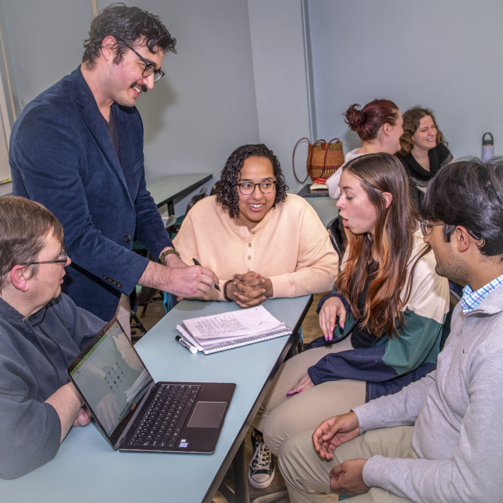 Group of students gathered around a professor