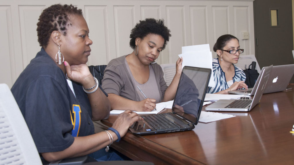 Students in Ed.D. program at conference table with laptops