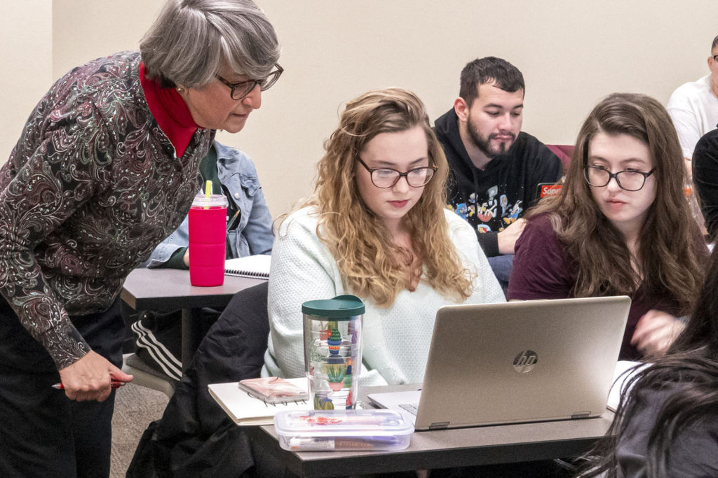 Professor Gabrenya from Sage's criminal justice program assists students in a classroom.