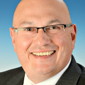 Caucasian bald man with glasses wearing a suit.