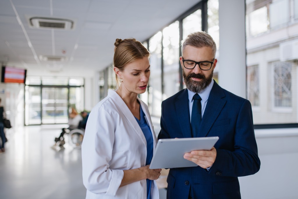 pharma rep with a tablet speaking with a doctor