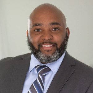 Man in business suit smiling at camera.