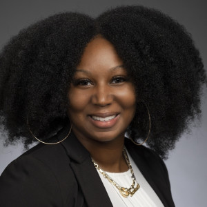 Professional smiling at the camera dressed in a suit.