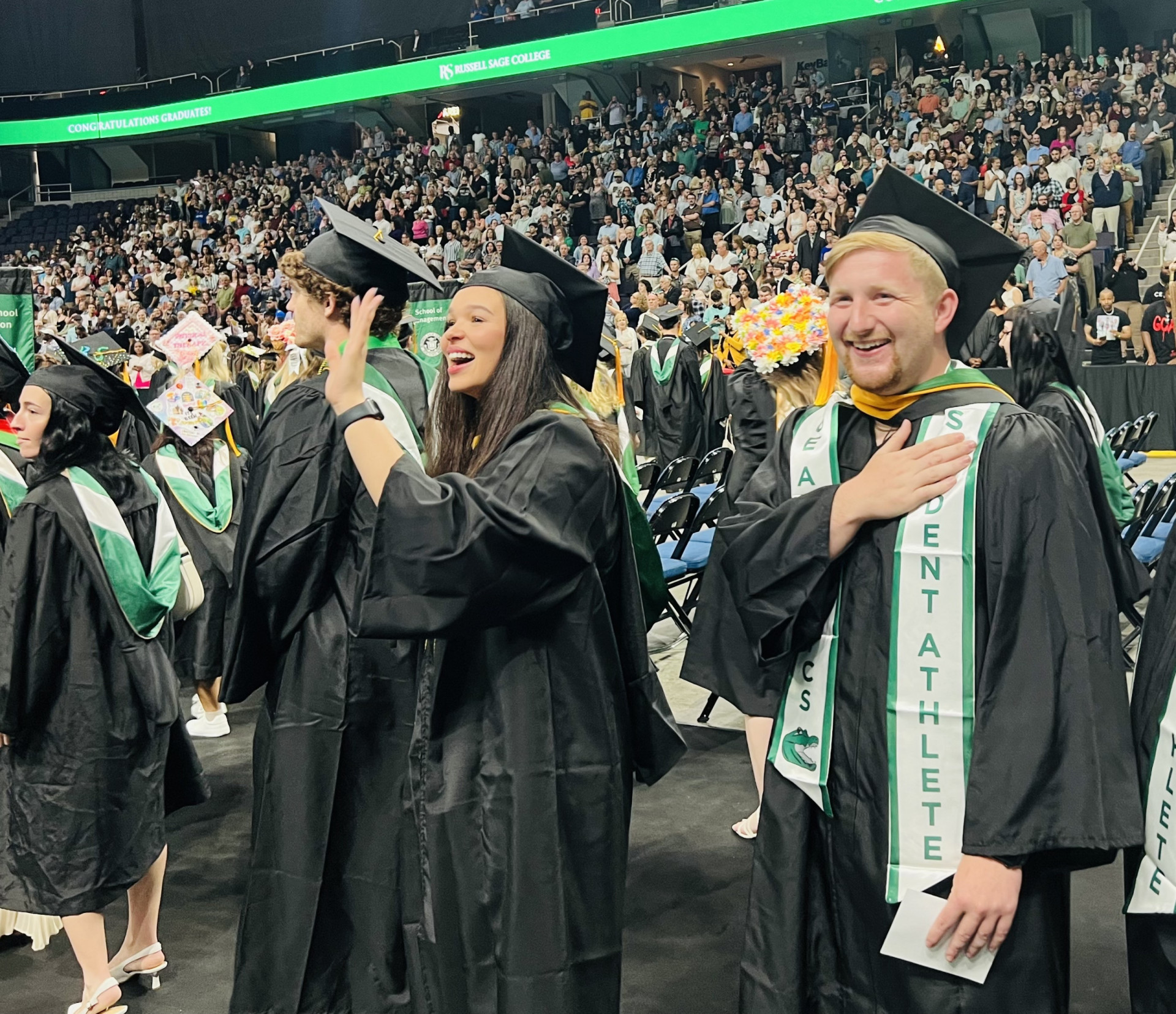 A large group of college graduates dressed in caps and gowns at commencement.