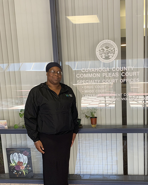 Person standing in front of a window labeled "Cuyahoga County Common Pleas Court Specialty Court Offices."