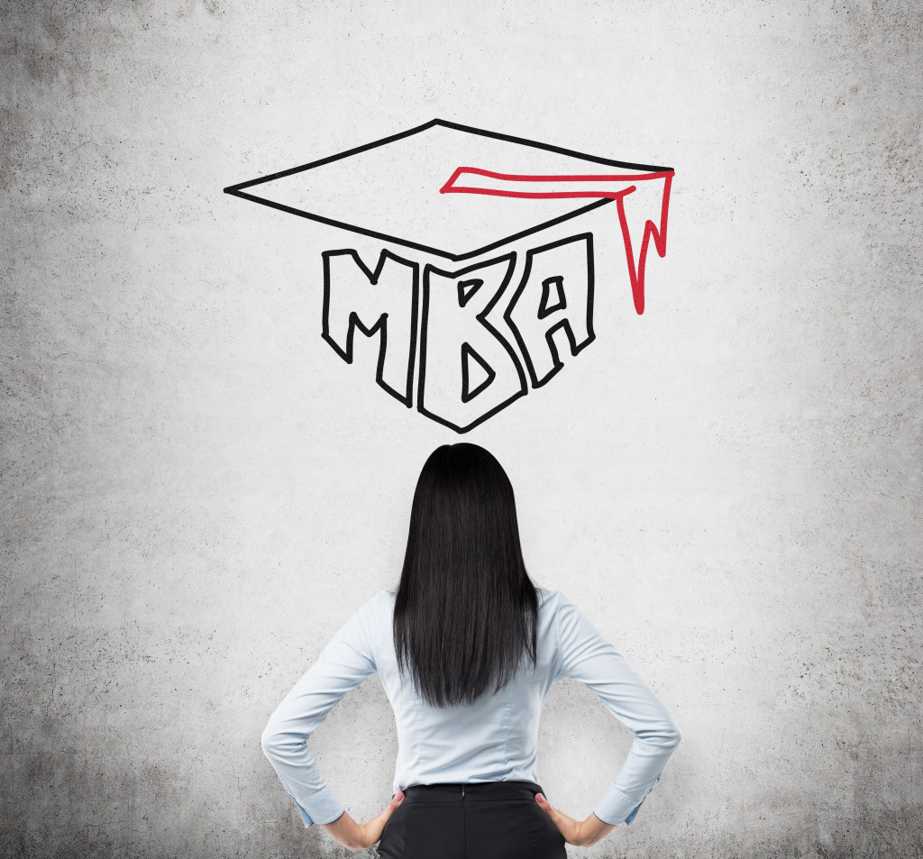 Businesswoman facing wall with MBA graduation cap illustration, symbolizing the decision to pursue a Master of Business Administration degree.