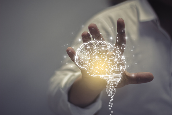Person reaching toward a digital brain illustration, representing the study of psychology, mental processes, and human behavior.