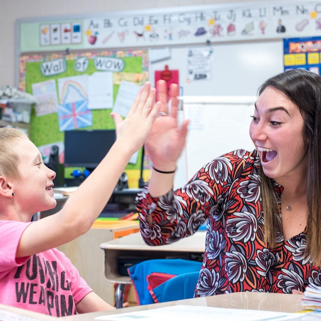 Student teacher high fives student