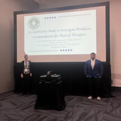 Two people standing next to a presentation screen in a conference room