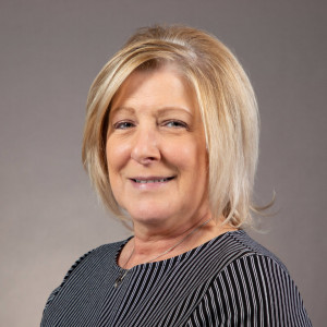 Professional woman smiling with gray background